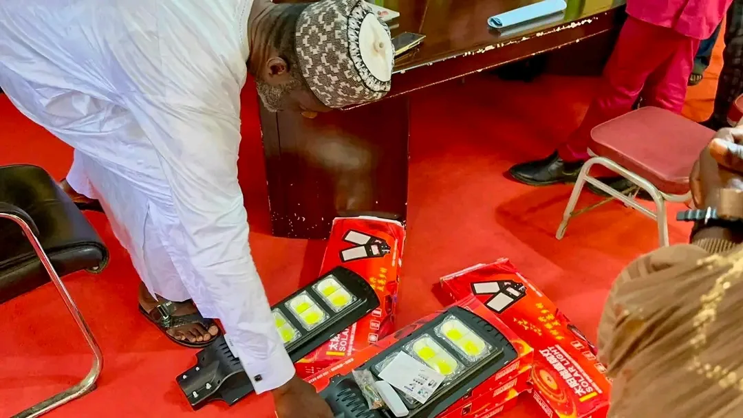 Greg Mewanu inspecting state of solar lights