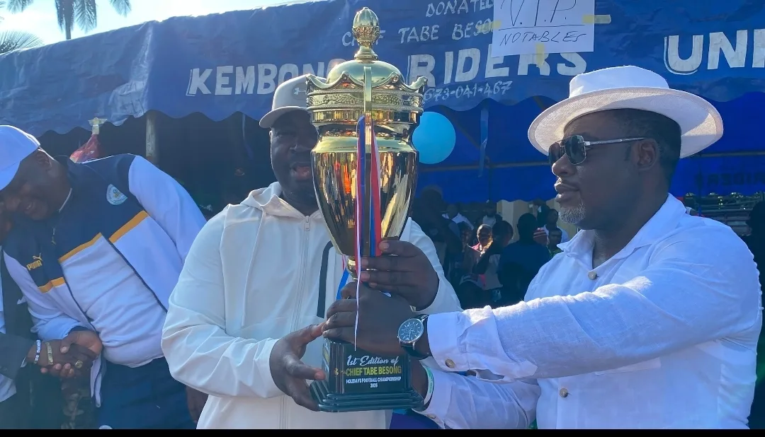 The SDO of Manyu and the cup donor presenting the trophy to the champions of the Football for peace tournament in Kembong